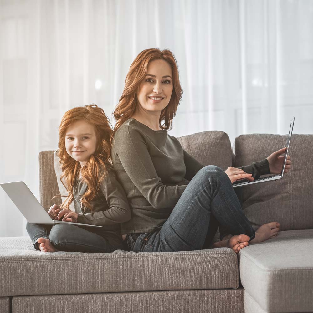 North Wales Computer Repair's Sitemap page. We offer a range of computer repair services. Photo shows a nother and daughter sitting back-to-back using their laptops.